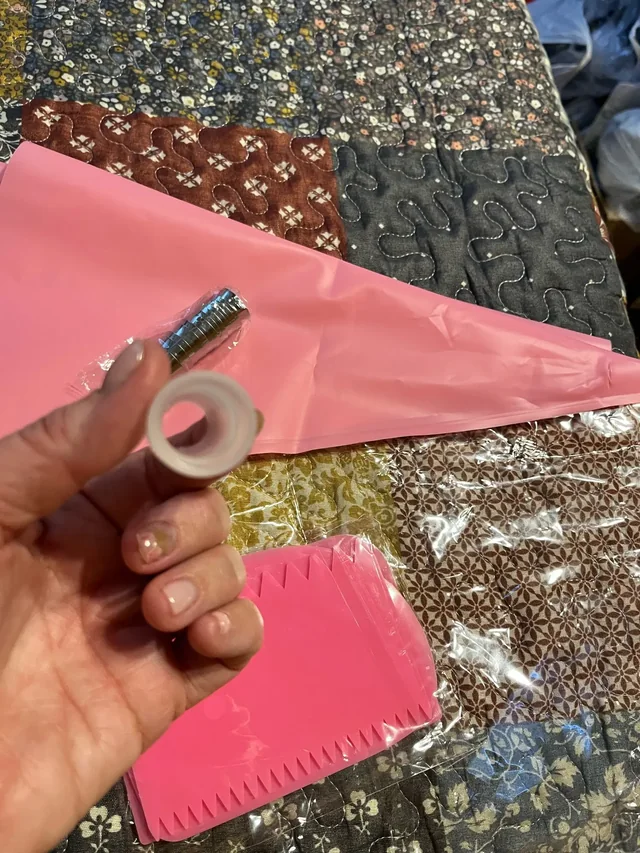 Acheteuse tenant la bague du coupleur, avec les douilles inox emballées et la poche rose du kit