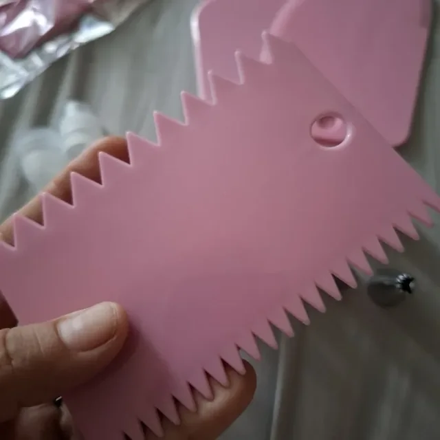 Gros plan sur le lisseur rose à bords dentelés du kit, tenu en main — photo d'un acheteur vérifié